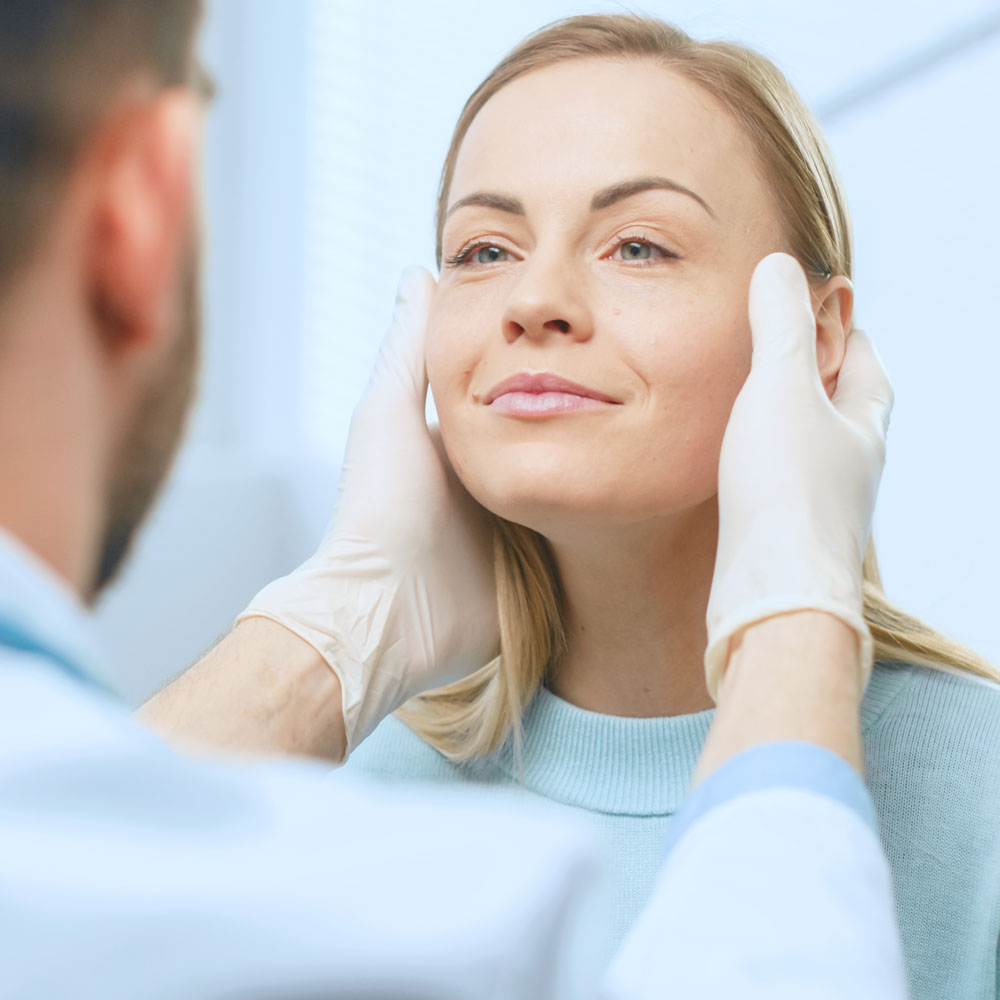 image of a white woman having her face examined by a doctor