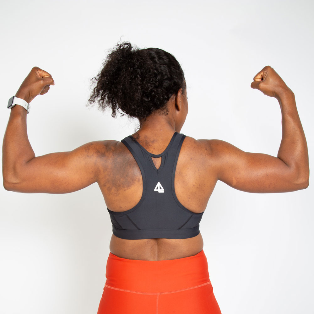 image from behind of a black woman flexing her muscles