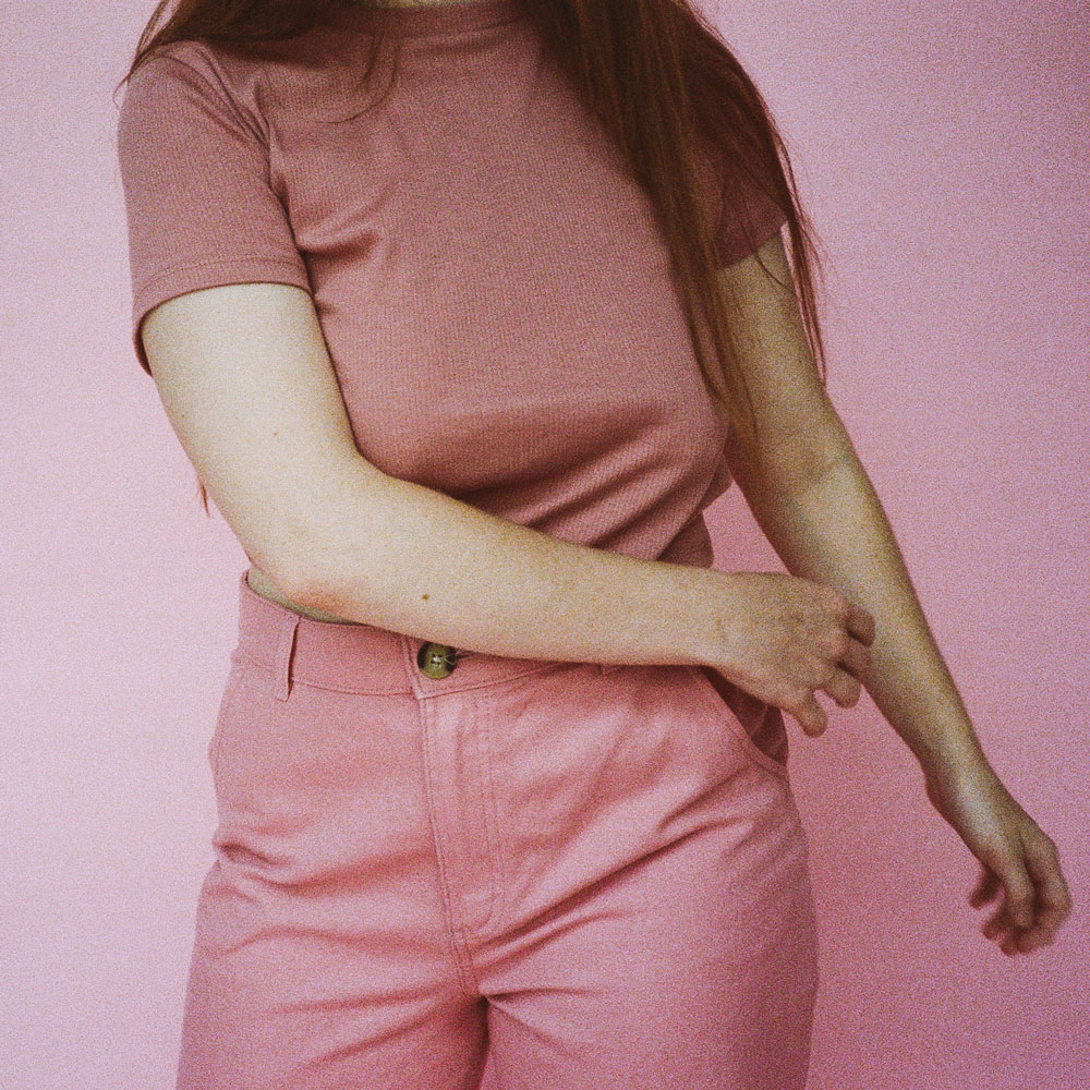 image of a woman's torso wearing a pink top and pink jeans
