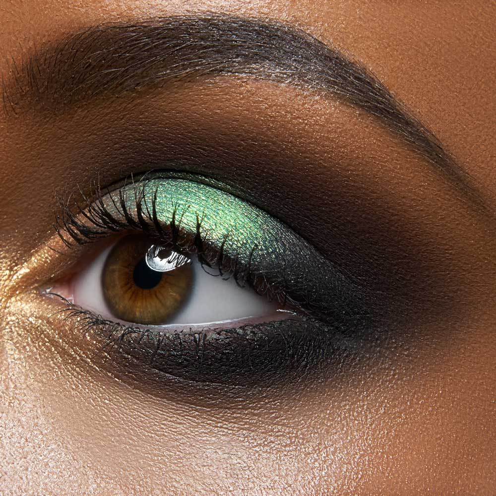 close up of black woman eye wearing green eye shadow