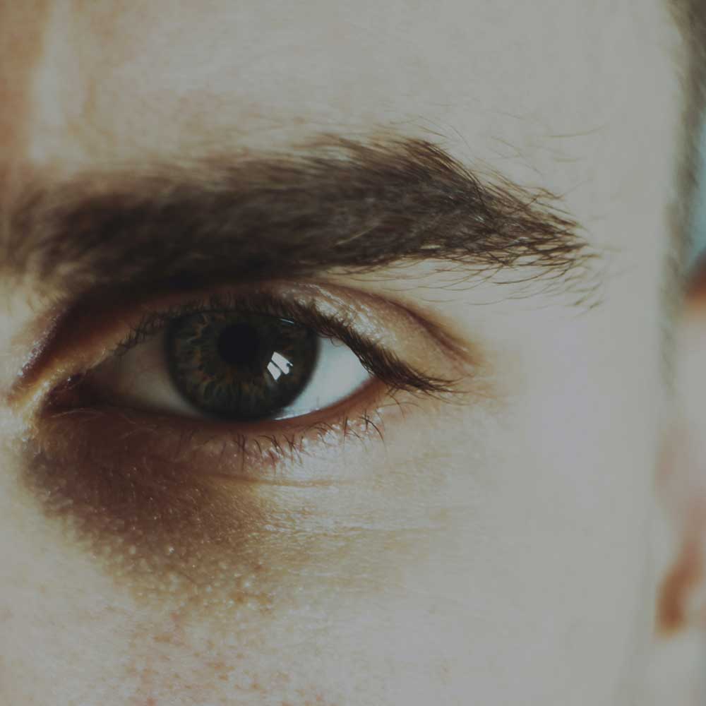 close up of white mans dark eyebrow and eye