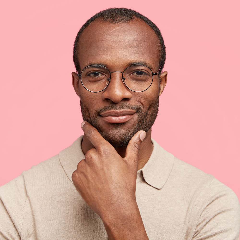 image of a black mans head and shoulders with hand on his chin smirking