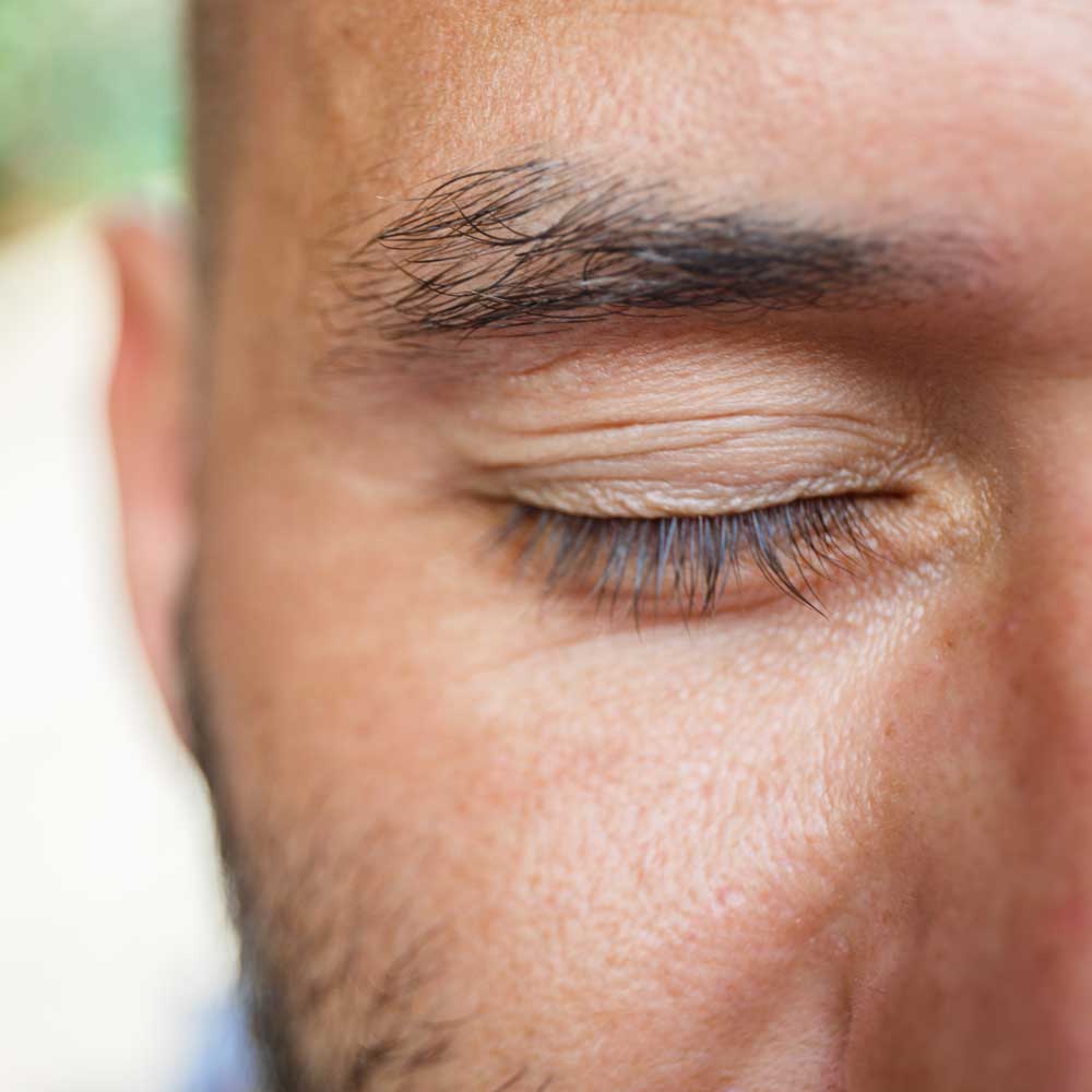 close up of a white man's closed eye